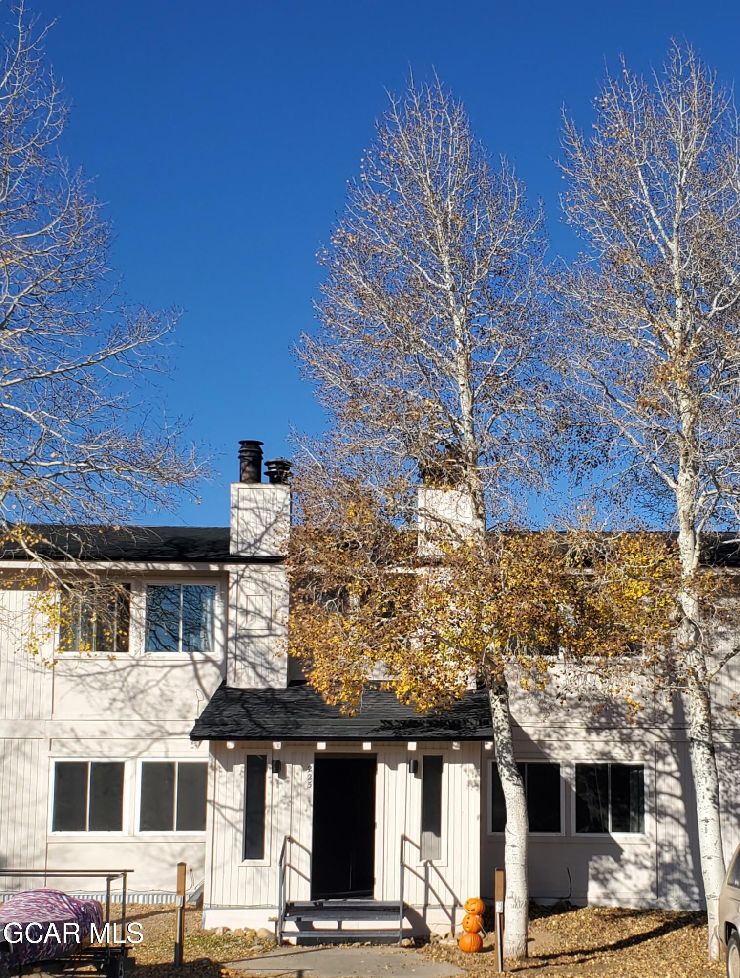 a front view of a building with streets and trees