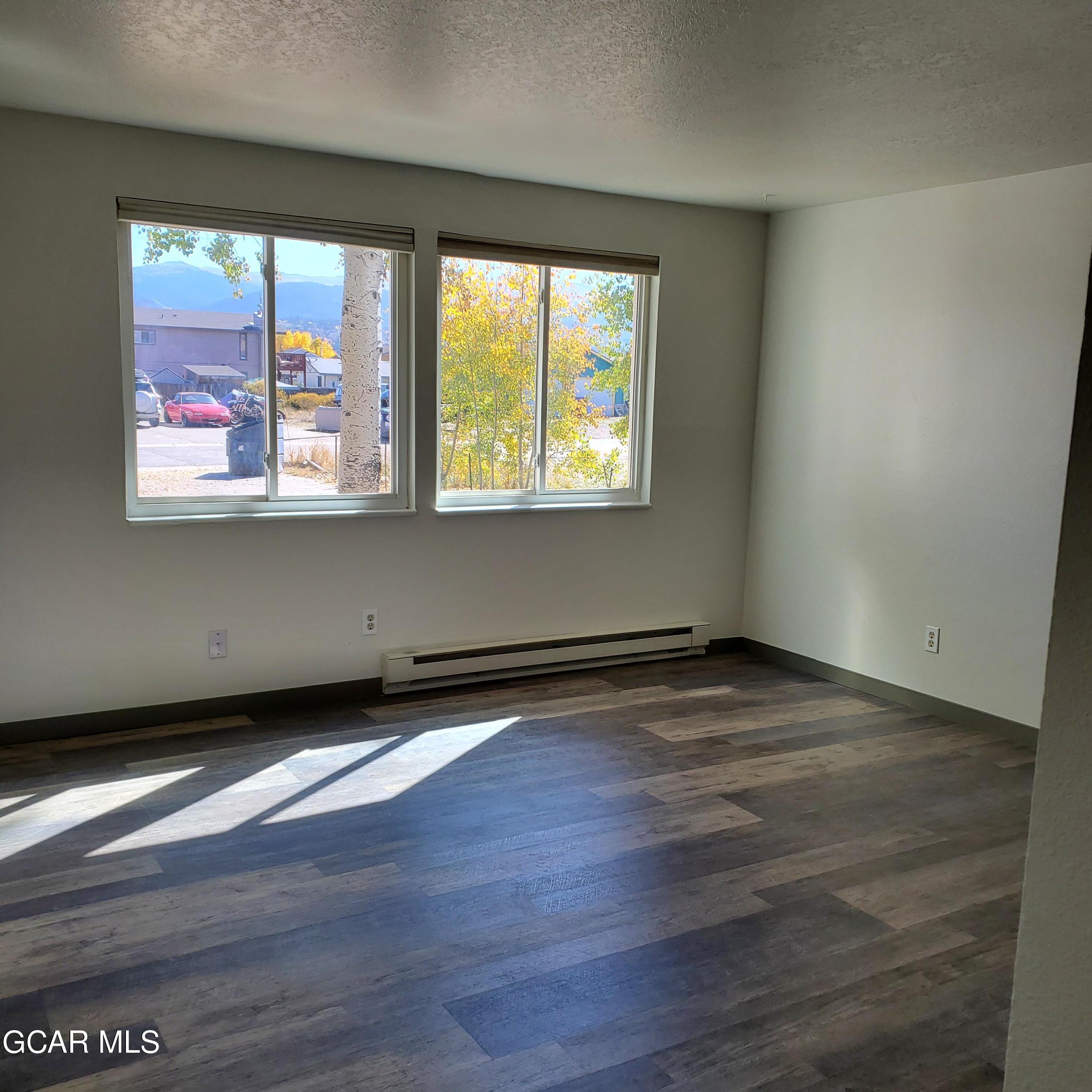 225 Carriage Road Fraser, CO 80442 - Photo 2 of 11 a view of an empty room with wooden floor and a window