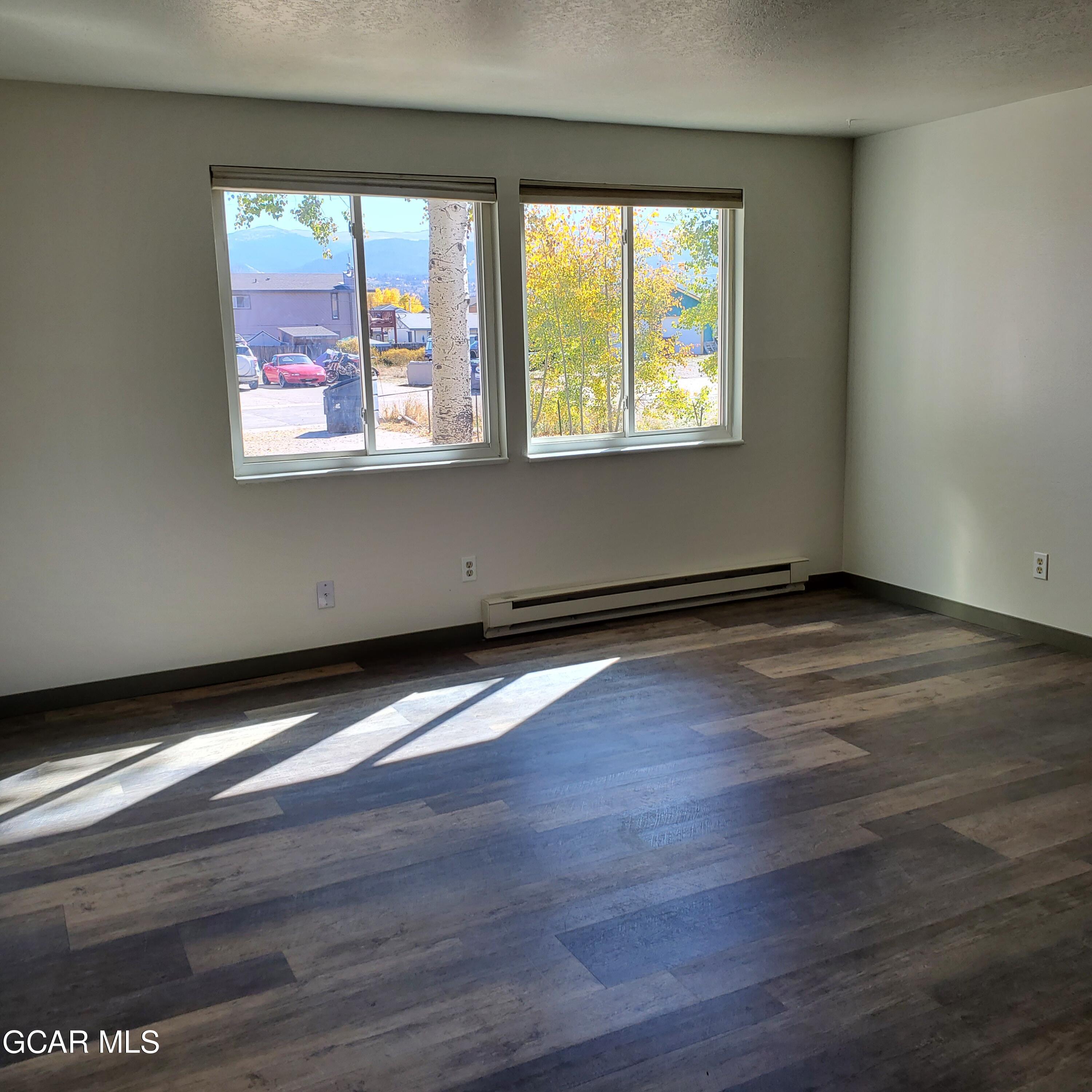 225 Carriage Road Fraser, CO 80442 - Photo 3 of 11 a view of an empty room with wooden floor and a window