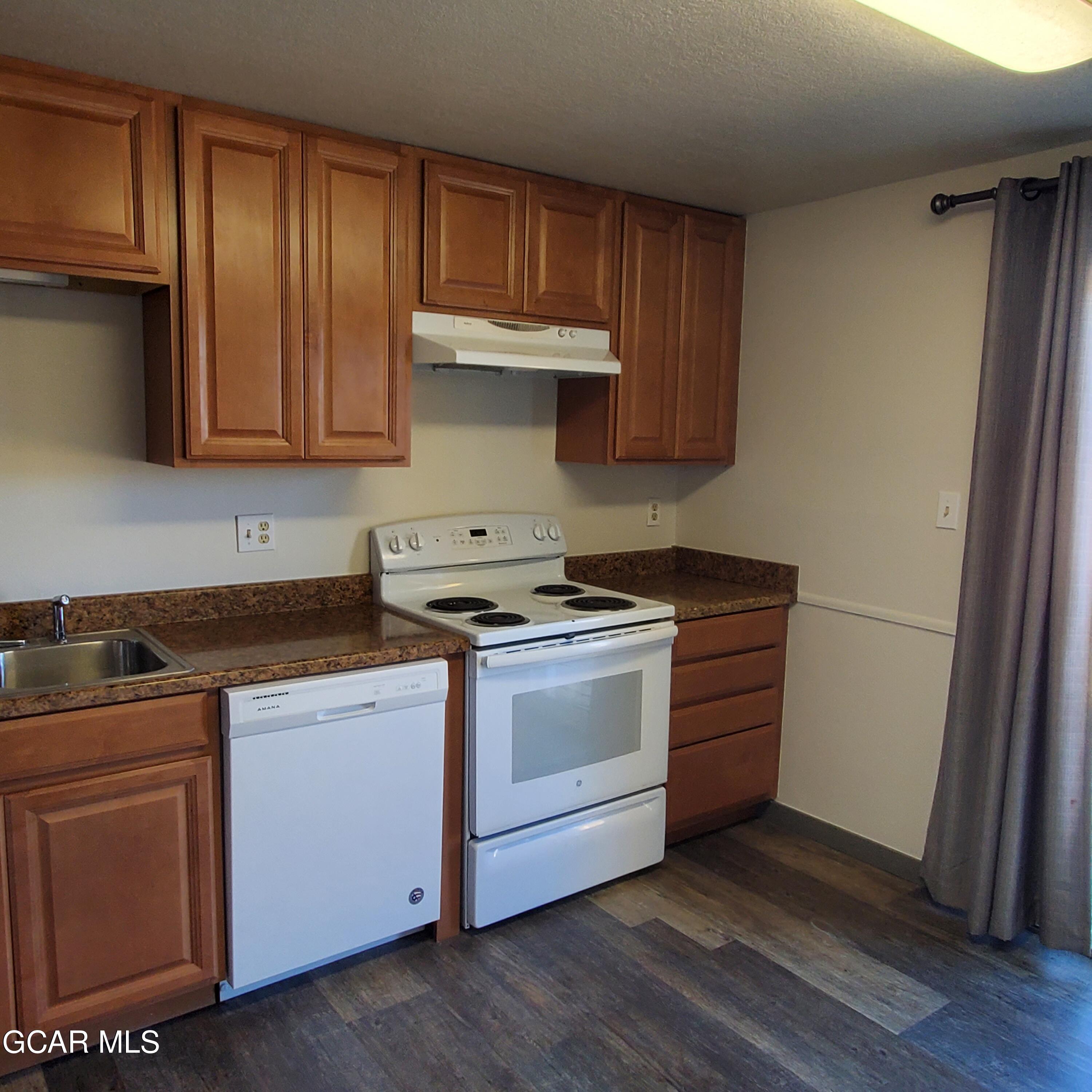 225 Carriage Road Fraser, CO 80442 - Photo 4 of 11 a kitchen with granite countertop wooden cabinets and a stove