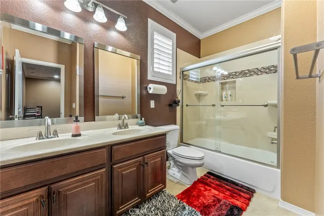 a bathroom with a double vanity sink toilet and shower