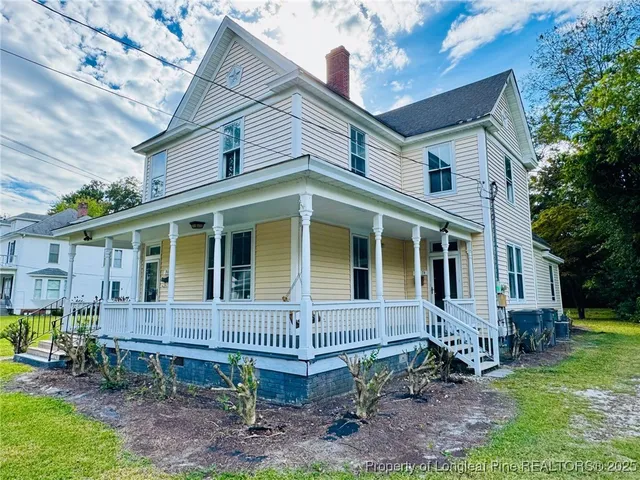a view of a house with a yard and sitting area