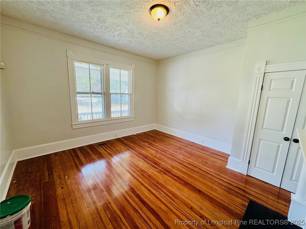 907 Caldwell Street, Unit A Lumberton, NC 28358 - Photo 13 of 24 a view of an empty room with wooden floor and a window