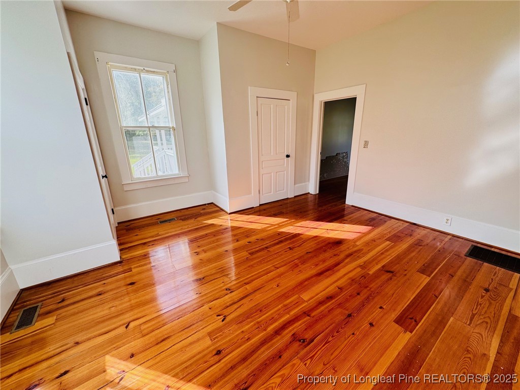 907 Caldwell Street, Unit A Lumberton, NC 28358 - Photo 18 of 24 a view of an empty room with wooden floor and a window