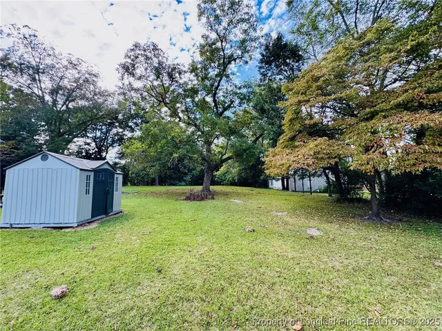 a view of a backyard with large trees