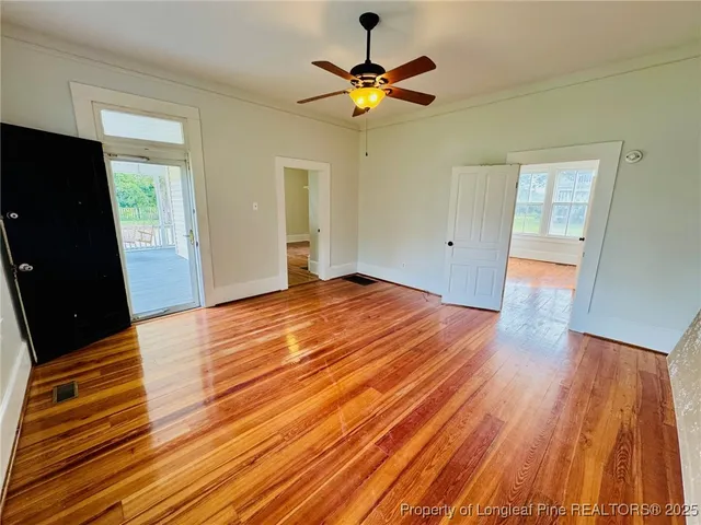 a view of an empty room with wooden floor