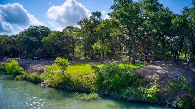 a view of a yard with plants and lake view
