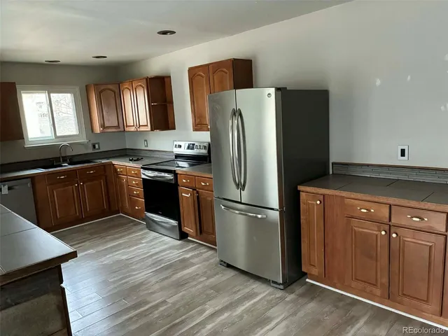 a kitchen with stainless steel appliances granite countertop a refrigerator stove and sink