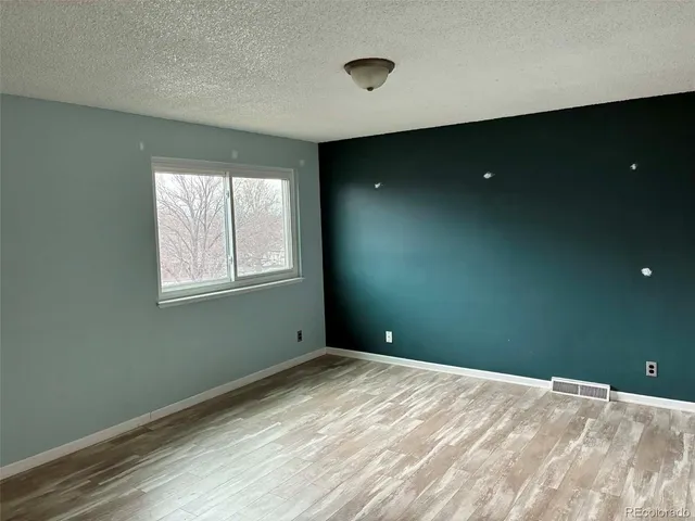 a view of an empty room with closet and a window