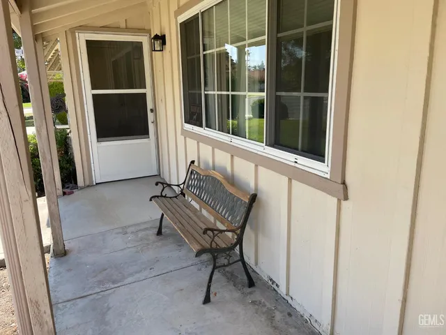 a view of a door with a chair and bench in the porch