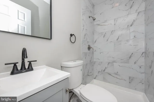 a bathroom with a sink a toilet and a mirror