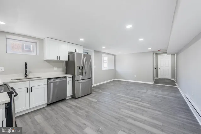 a kitchen with stainless steel appliances granite countertop a sink cabinets and wooden floor