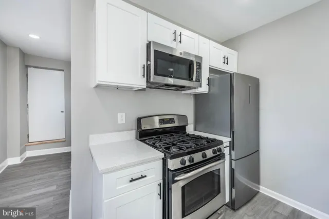 a kitchen with stainless steel appliances white cabinets and a stove