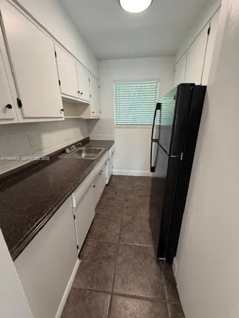 a kitchen with granite countertop a refrigerator and a stove