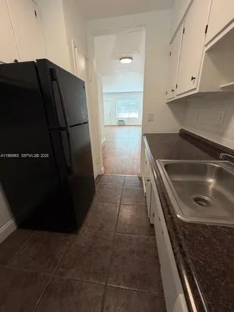 a kitchen with a refrigerator and a sink