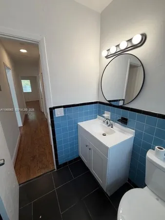 a bathroom with a sink mirror vanity and toilet