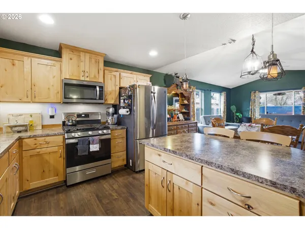 a kitchen with stainless steel appliances granite countertop a sink a stove and a refrigerator
