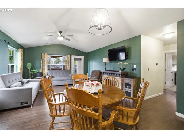 a living room with furniture kitchen and a flat screen tv