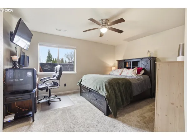 a bedroom with a bed gym equipment and view of living room