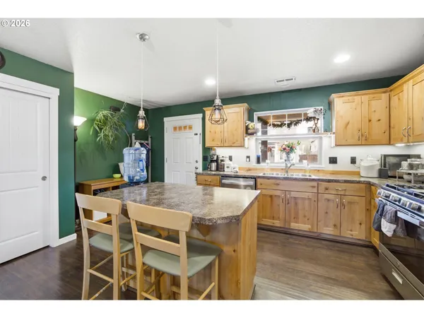 a kitchen with kitchen island granite countertop wooden cabinets and white appliances