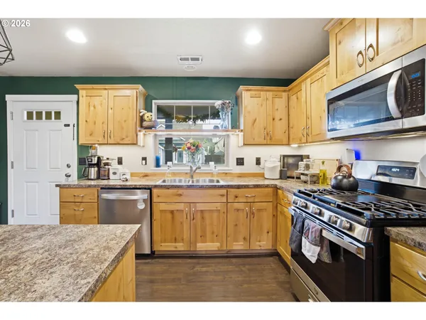 a kitchen with stainless steel appliances granite countertop a sink stove and cabinets