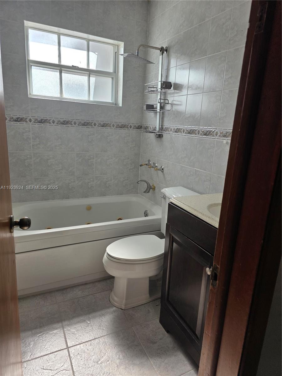 1560 West 53rd Terrace, Unit 1560 Hialeah, FL 33012 - Photo 16 of 28 a bathroom with a toilet a sink and bathtub
