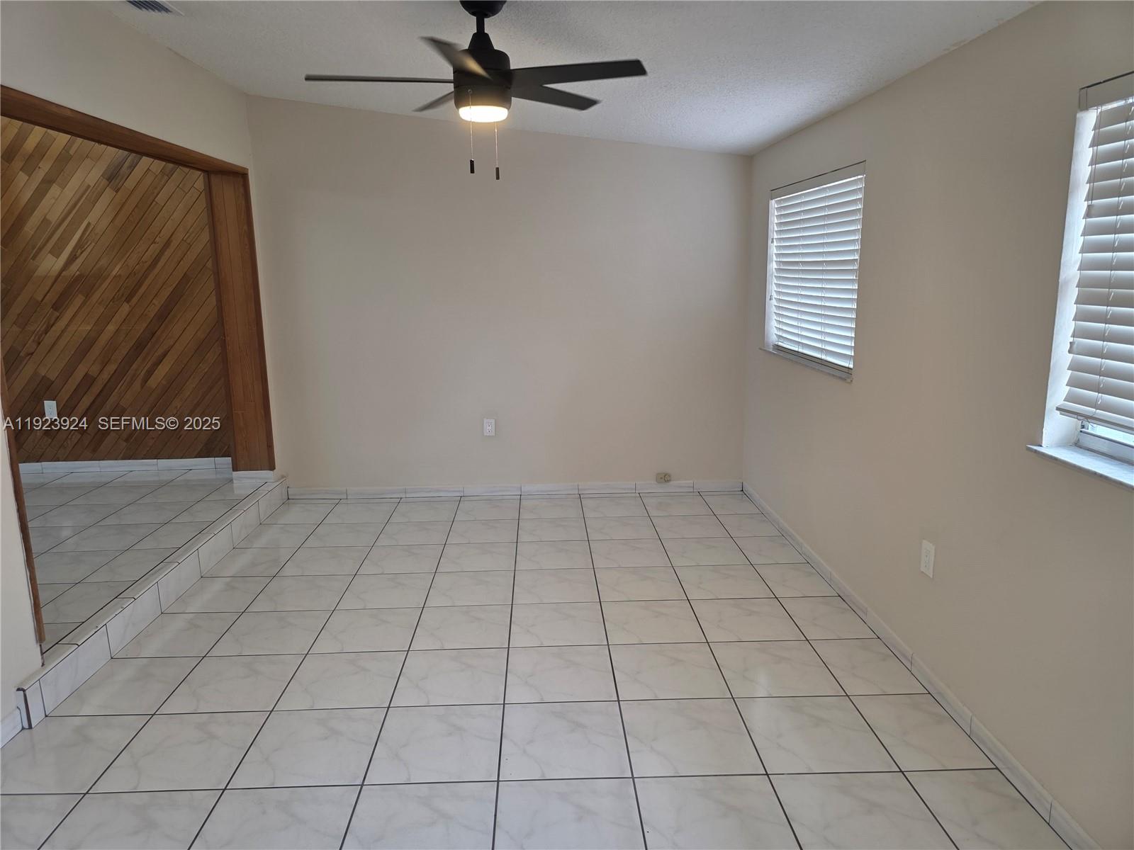1560 West 53rd Terrace, Unit 1560 Hialeah, FL 33012 - Photo 22 of 28 an empty room with windows and fan