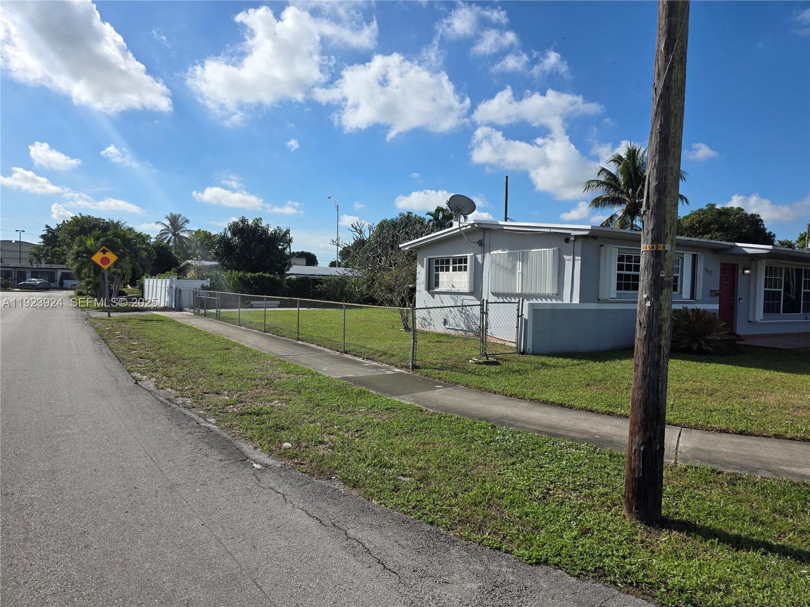 1560 West 53rd Terrace, Unit 1560 Hialeah, FL 33012 - Photo 27 of 28 a view of a house with a big yard and a large tree