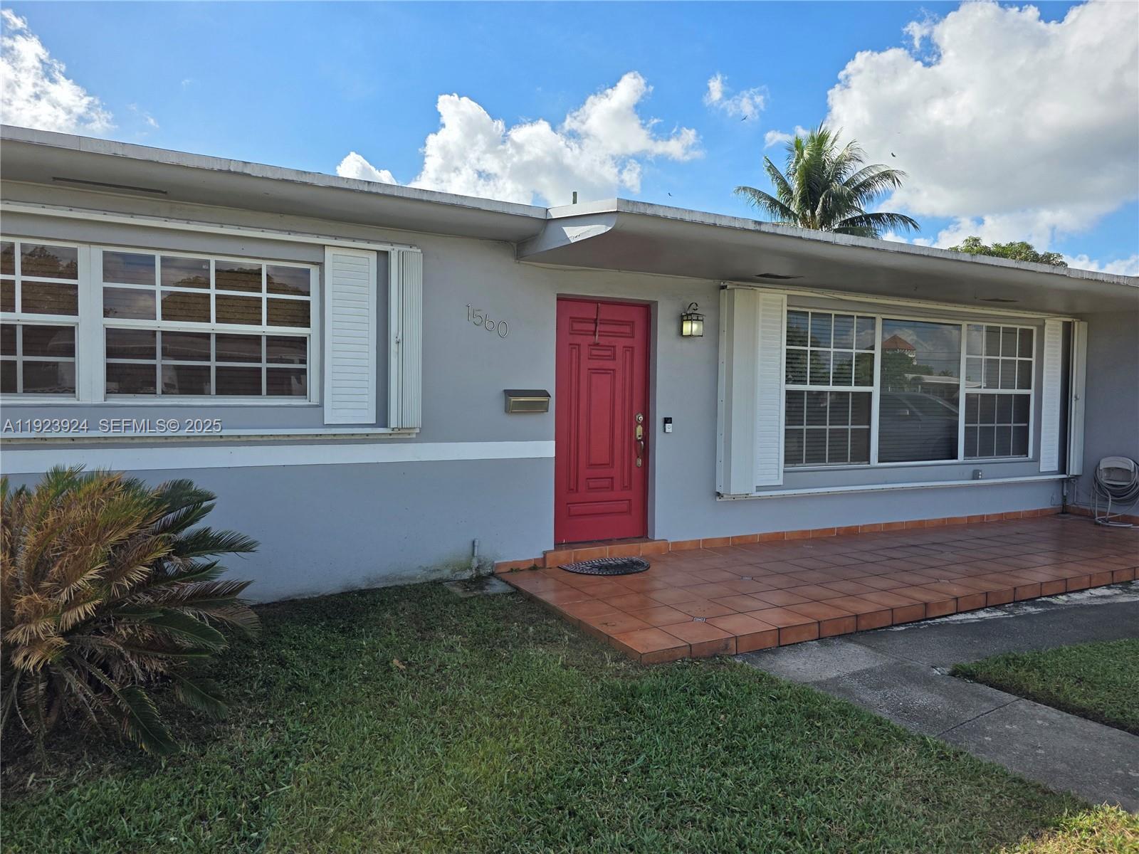 1560 West 53rd Terrace, Unit 1560 Hialeah, FL 33012 - Photo 4 of 28 a front view of a house with a yard