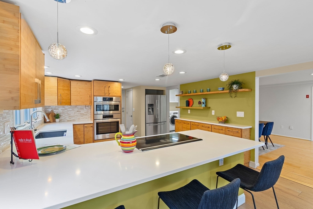 33 Turning Mill Road Lexington, MA 02420 - Photo 14 of 42 a kitchen with a table chairs and a view of living room