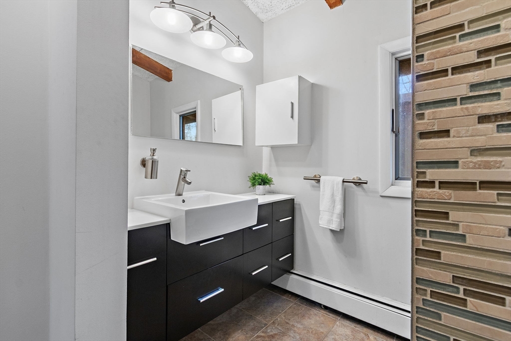 33 Turning Mill Road Lexington, MA 02420 - Photo 24 of 42 a bathroom with a sink a mirror and shower
