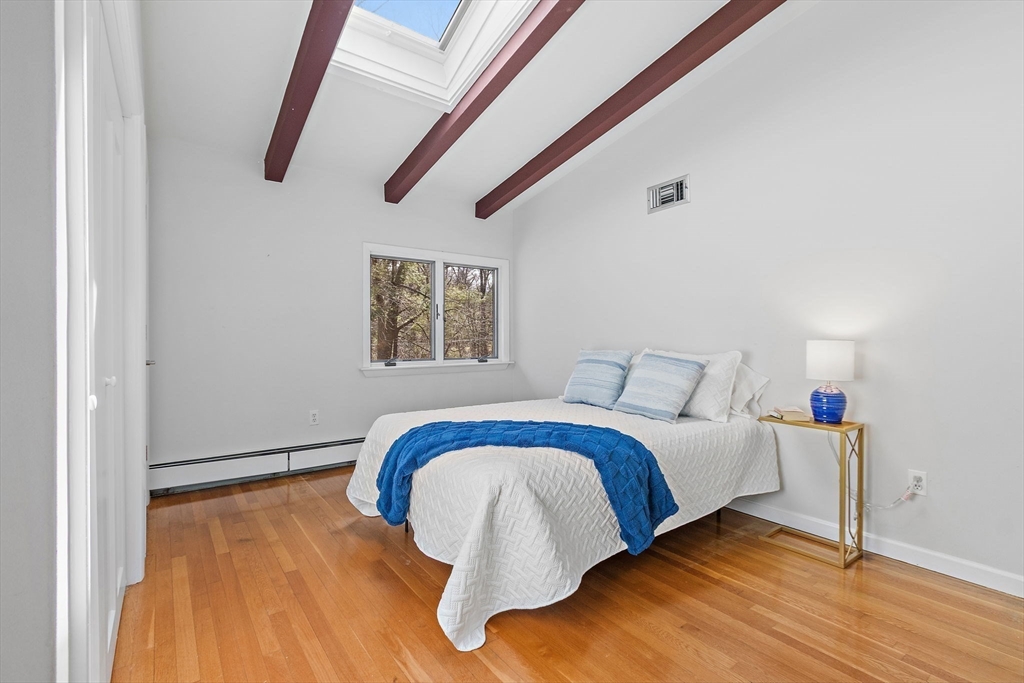 33 Turning Mill Road Lexington, MA 02420 - Photo 25 of 42 a bedroom with a bed and a painting on the wall