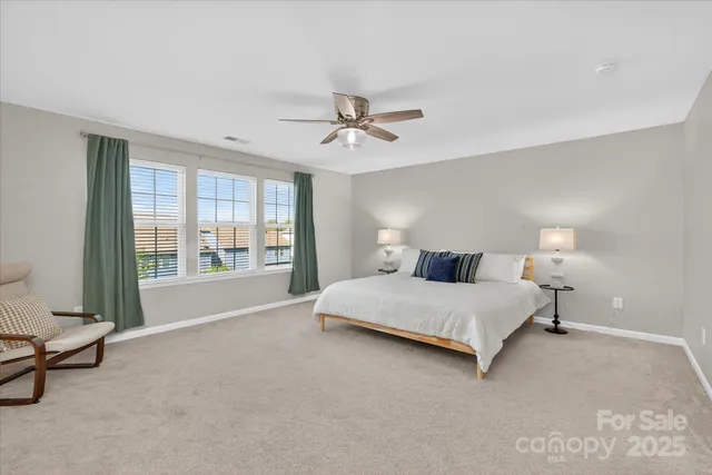 a spacious bedroom with a bed and a chandelier