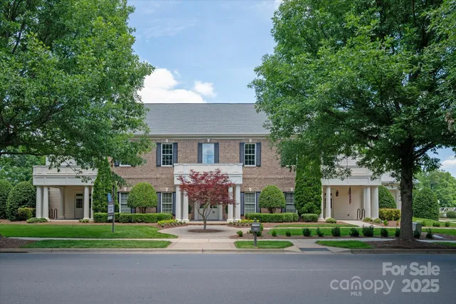 a front view of a house with a yard and trees