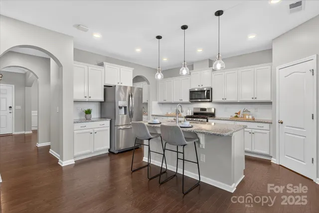 a kitchen with a refrigerator a sink and cabinets
