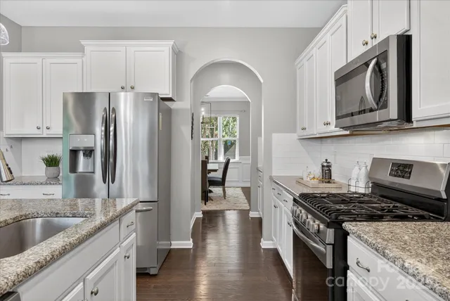 a kitchen with stainless steel appliances granite countertop a stove a sink dishwasher a refrigerator and a microwave oven