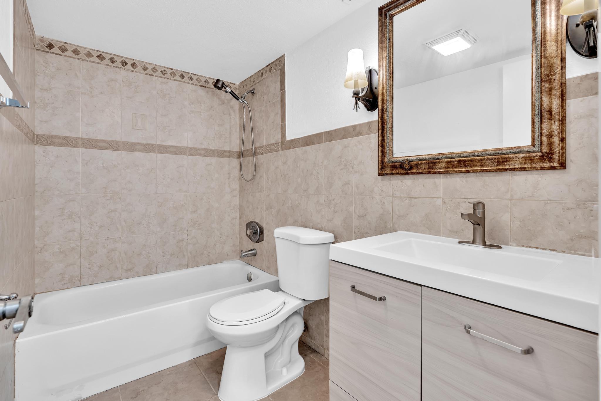1291 Northwest 13th Street, Unit 445D Boca Raton, FL 33486 - Photo 38 of 50 a bathroom with a sink a toilet and a mirror