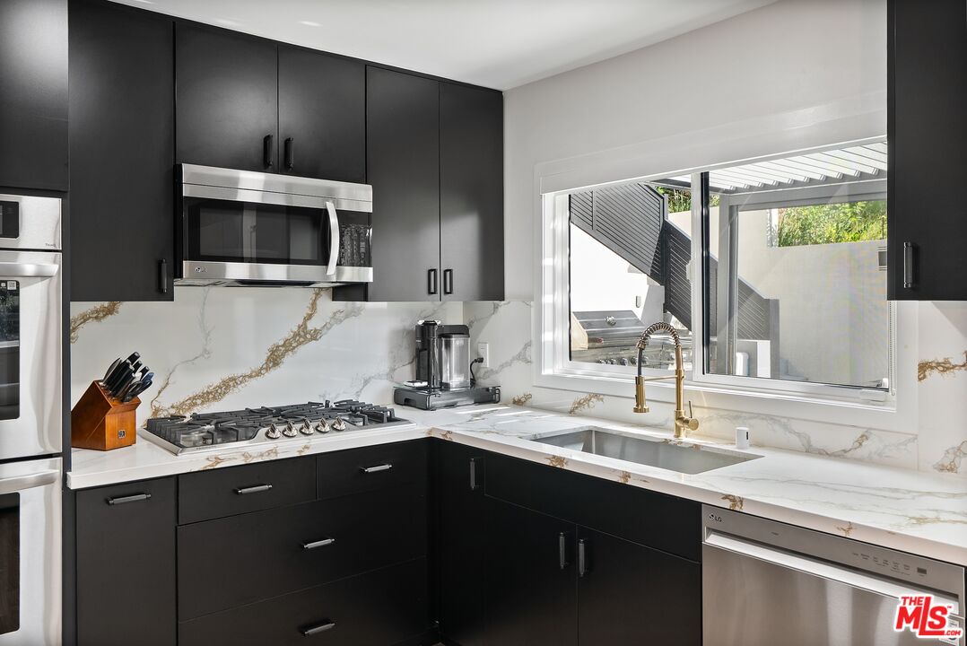 4118 Oak Hollow Road Calabasas, CA 91302 - Photo 21 of 55 a kitchen with a sink and a stove