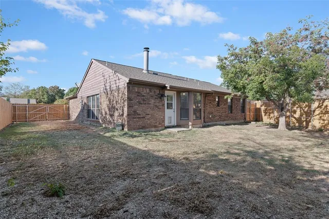 a view of a house with backyard and a tree