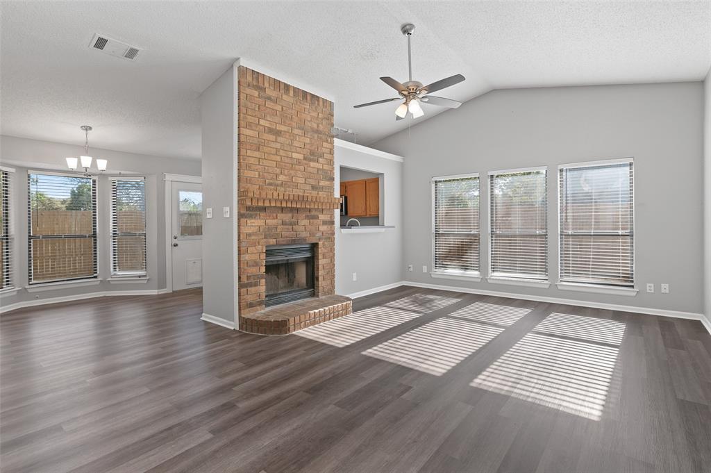 3521 Glenview Drive Corinth, TX 76210 - Photo 24 of 24 an empty room with wooden floor fireplace and windows