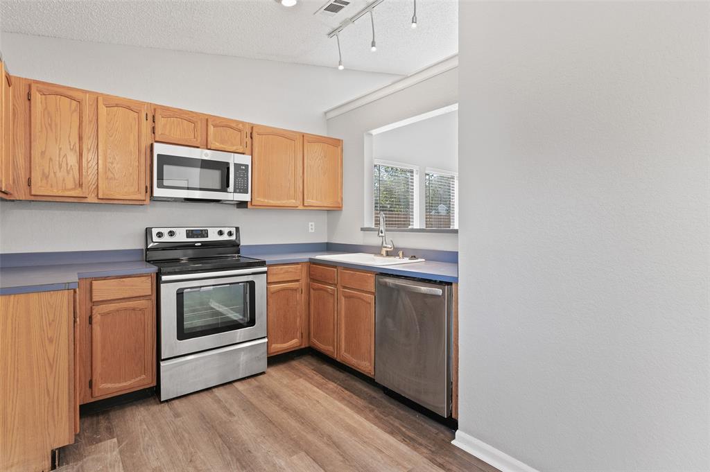 3521 Glenview Drive Corinth, TX 76210 - Photo 6 of 24 a kitchen with stainless steel appliances granite countertop a stove a sink and a microwave