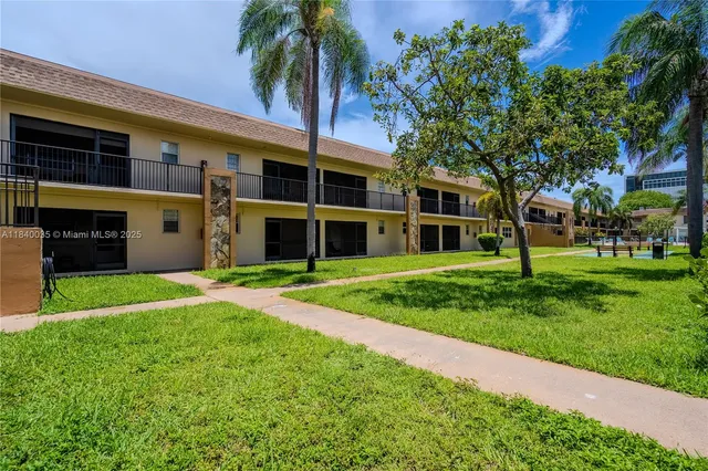 a view of a house with a yard and palm trees