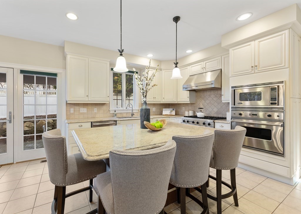 21 Ellison Road Lexington, MA 02421 - Photo 8 of 42 a kitchen with a dining table chairs stainless steel appliances and cabinets