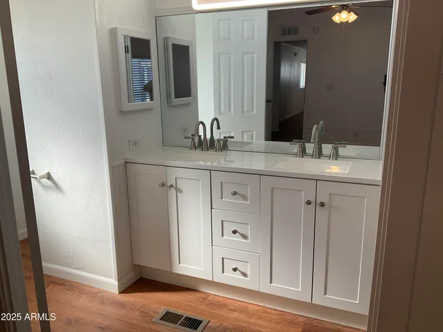 a spacious bathroom with a granite countertop sink and a mirror