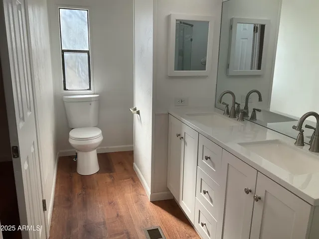 a bathroom with a toilet sink and mirror