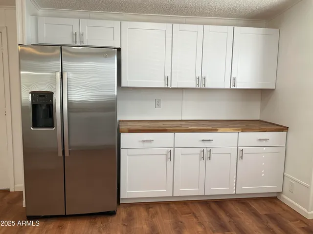 a kitchen with cabinets and a refrigerator