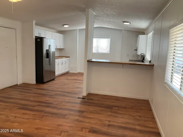 a view of empty room with wooden floor and windows