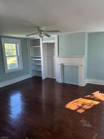 a view of empty room with wooden floor and fireplace