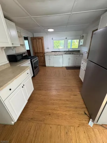 a kitchen with stainless steel appliances wooden floors and view