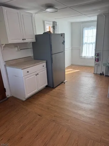 a kitchen with stainless steel appliances white cabinets and wooden floors